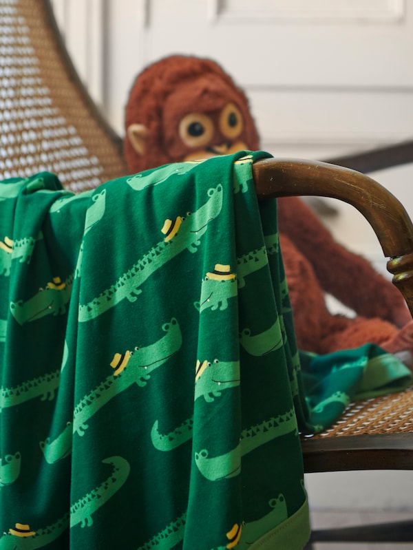 RORANDE毯的手臂搭在椅子上有一个DJUNGELSKOG猩猩软玩具。