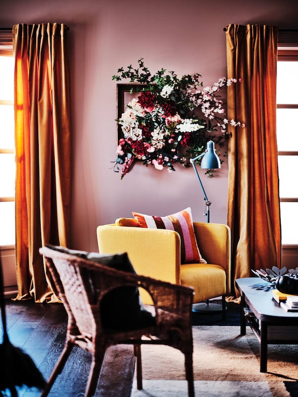 居住面积与缓冲在粉红色/条纹VATTENVAN靠垫Skiftebo黄色EKERO扶手椅在地毯上。