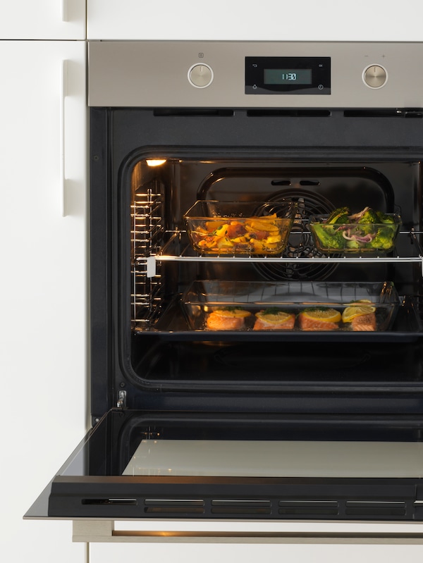 一个ANRATTA强迫烤箱玻璃与不锈钢门和三个烤箱托盘与不同种类的食物。