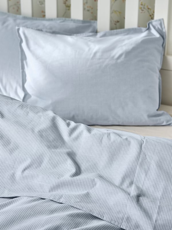 浅蓝色条纹BERGPALM床上用品在白色的床上。