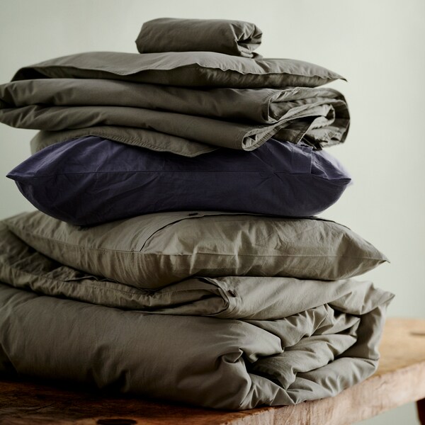 轻轻地折叠的床用织物包括KRAKRISMOTT被套和枕套绿色和蓝色。