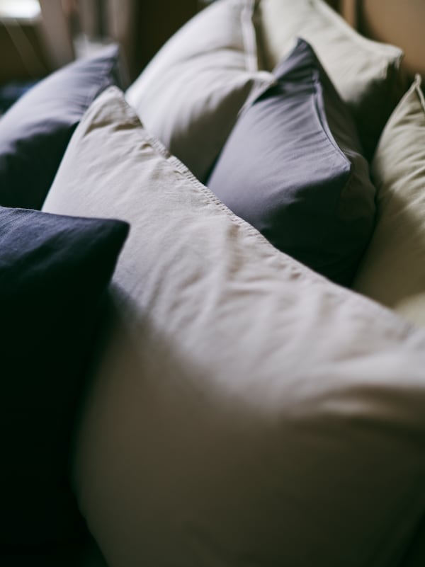 舒适的特写ANGSLILJA枕套grey-beige,混合着黑灰色坐垫。