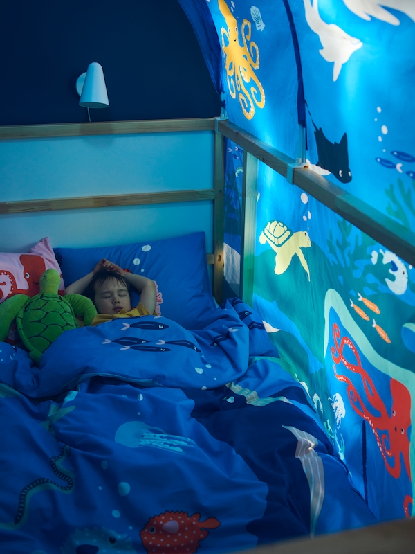 一个小男孩睡在BLAVINGAD海洋动物被套在库那床上覆盖的库那床帐篷。