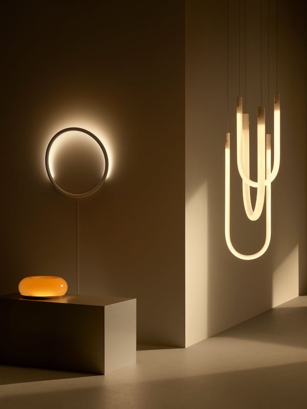 Beleuchtungsprodukte来自der VARMBLIXT Kollektion befinden西奇在einem abgedunkelten, minimalistischen Raum。阿莱Produkte信德eingeschaltet leuchten。