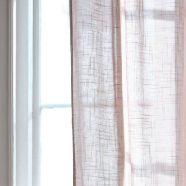 亮粉红色的一部分SILVERLONN纯粹的窗帘挂在一个明亮的窗口在一个阳光明媚的一天。