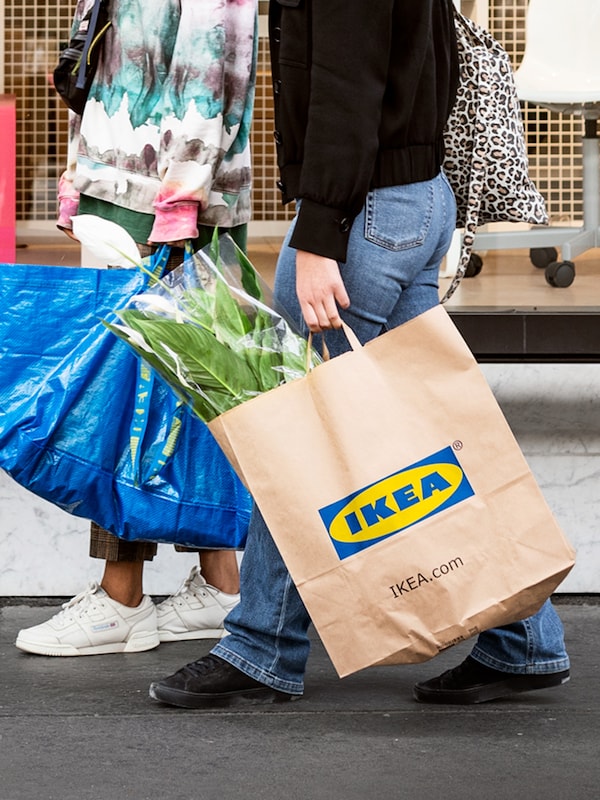 两人在宜家购物,一个带着一个蓝色FRAKTA包包含植物,另一个宜家的纸袋。亚博平台信誉怎么样