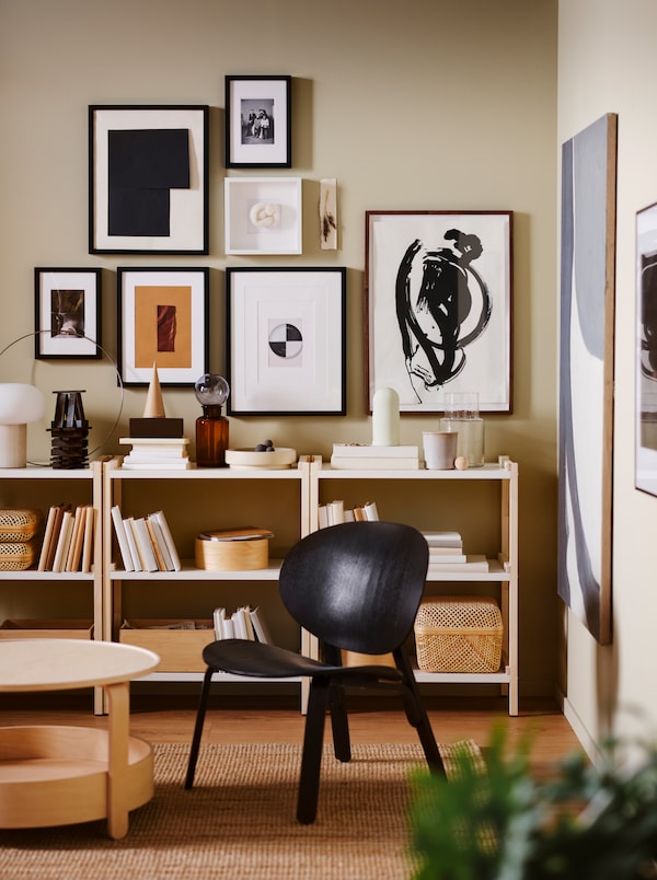 艺术墙与框架在各大小上面一排低搁置单元,加上一个黑色FROSET安乐椅黄麻地毯。