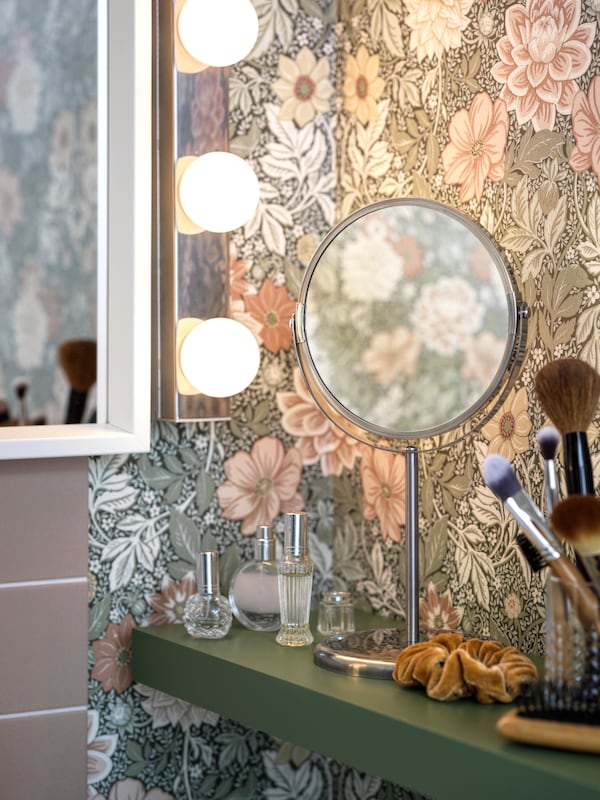 浴室的角落有花卉图案的墙壁和墙货架配件和TRENSUM不锈钢镜子。