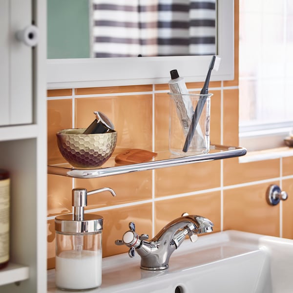 浴室水槽RUNSKAR丝锥,VOXNAN给皂器和VOXNAN玻璃架子上的橙色瓷砖浴室。