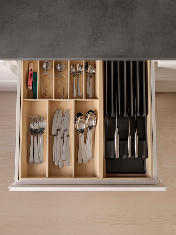 厨房的抽屉打开,有不锈钢餐具和刀具UPPDATERA刀具和刀盘竹子。