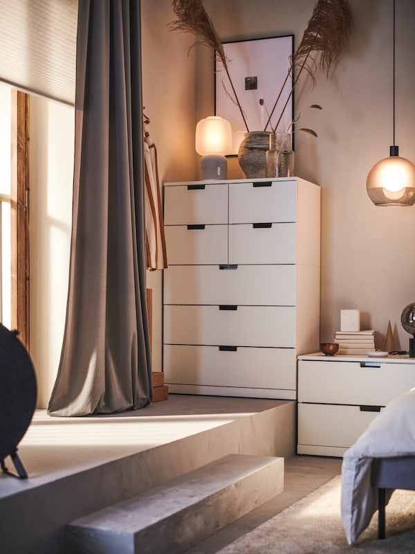 NORDLI衣柜7站在卧室的一个角落SYMFONISK议长灯与wi - fi和两个花瓶。