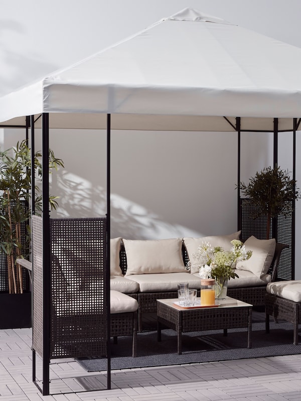 与白色的屋顶露台和深棕色的框架,与缓冲户外沙发和椅子,一张桌子和植物。