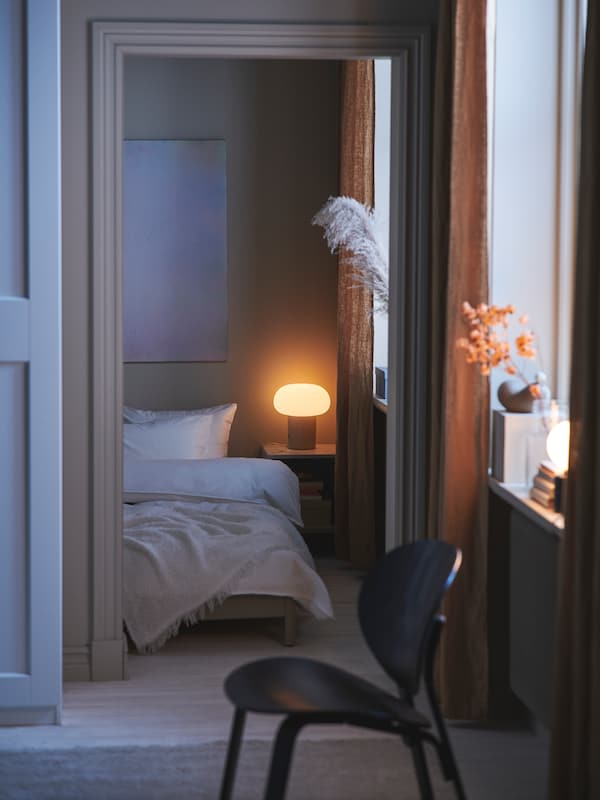 黑色染色橡木单板FROSET安乐椅站在前门口到卧室床和DEJSA台灯。