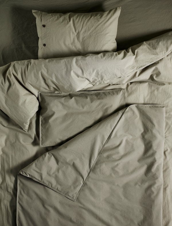 床上有一个KRAKRISMOTT被套和枕套亮绿色,恢复原状,松散折叠。