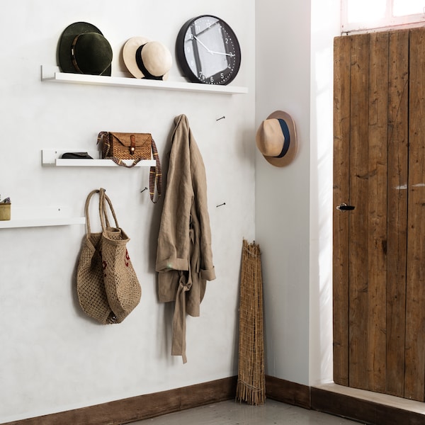 几个白色MOSSLANDA画壁板都是挂在门和走廊用作存储袋,帽子和一个时钟。