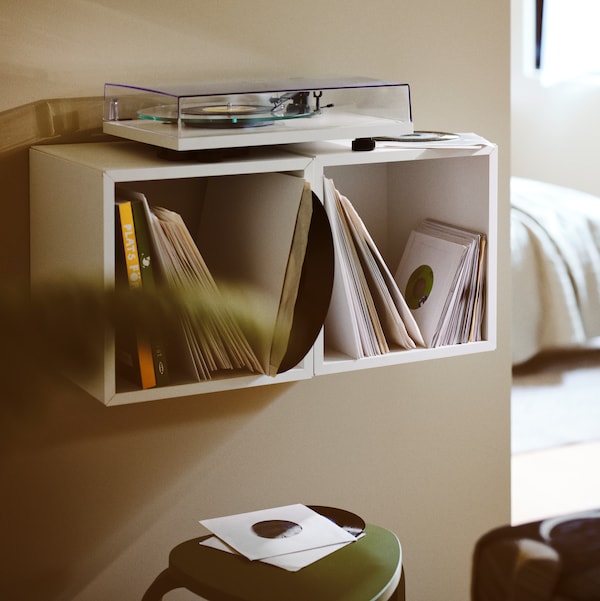 两个并排的唱机上白色EKET固定在墙上的书架内单位持有多个黑胶唱片。