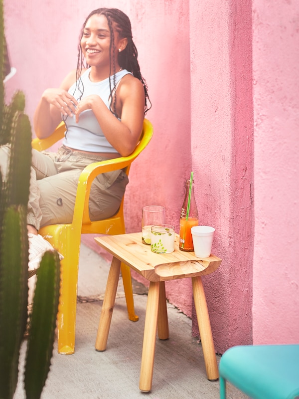 人的风景明信片sitzt伏尔静脉rosafarbenen魔杖neben einem klar lackierten OMSESIDIG典当者,der海尔als Beistelltisch genutzt将。