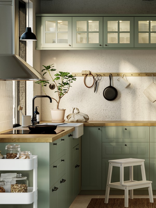厨房STENSUND浅绿色方面,GRUNDAD感应滚刀在黑色和壁挂式MATTRADITION器罩。