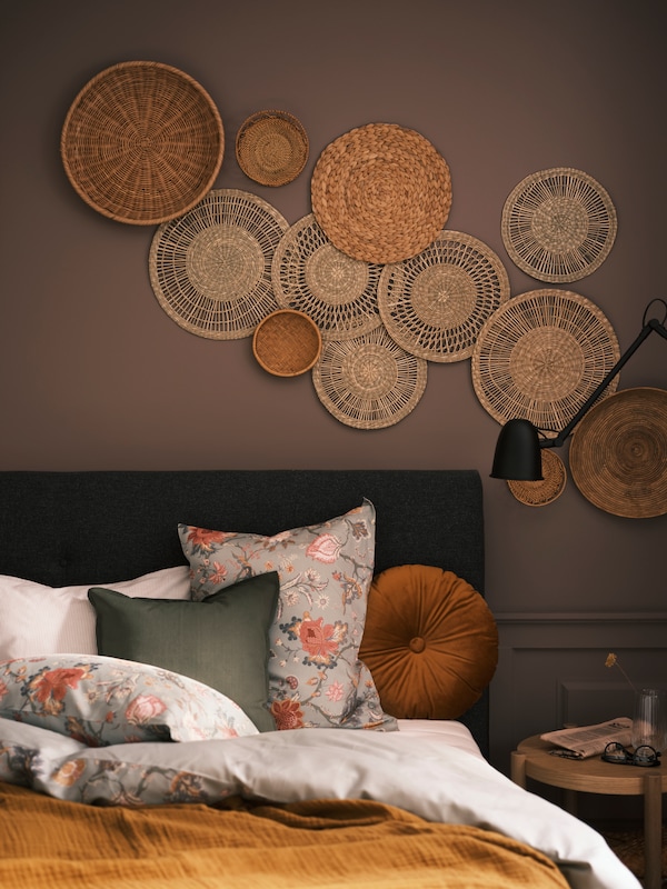 莎草GILLSTAD和其他墙装饰在墙上的床与光灰绿色,花卉图案NASSELKLOCKA床单。