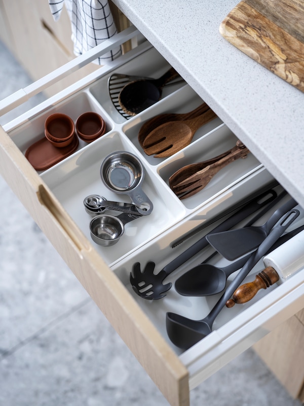 退出厨房抽屉揭示塑料厨具和竹子UPPDATERA餐具和餐具托盘。