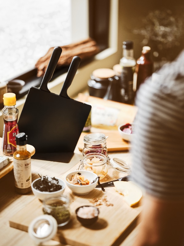 工作台和一个黑人JAMFORA刀与刀块,APTITLIG案板,KORKEN罐,和白色的碗。