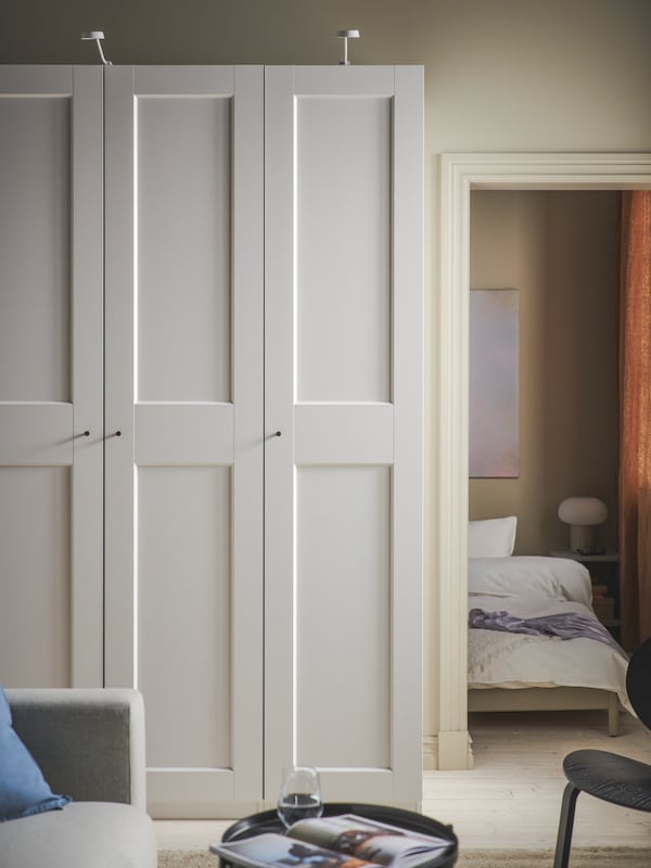 白色的罗马帝国/ GRIMO衣柜靠墙站在门口旁边成卧室,有一张床。