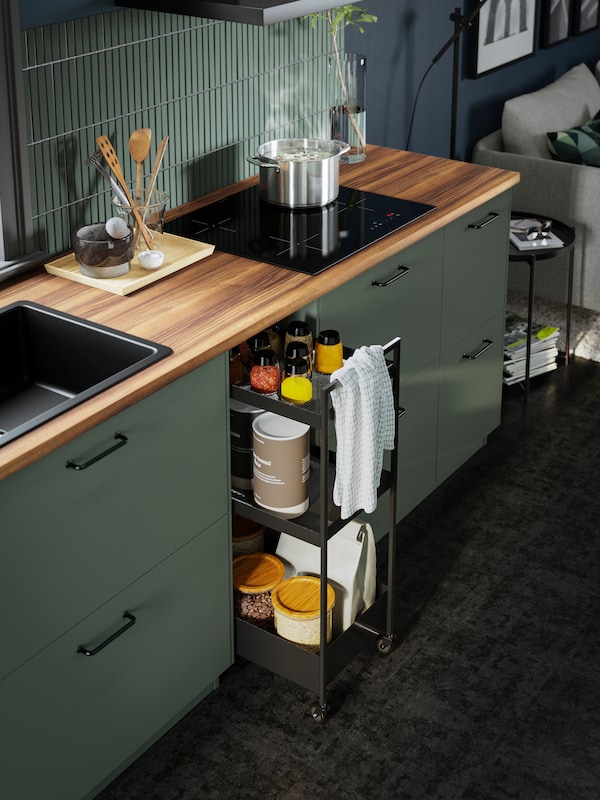 厨房与GRUNDAD感应滚刀4烹饪在绿色METOD厨房和布朗EKBACKEN胡桃木层压板的工作台。