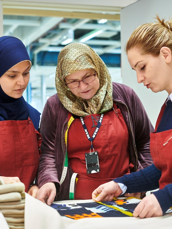 三个同事雅拉总统Trappan缝纫工作室在瑞典马尔默宜家商店,测量织物。亚博平台信誉怎么样
