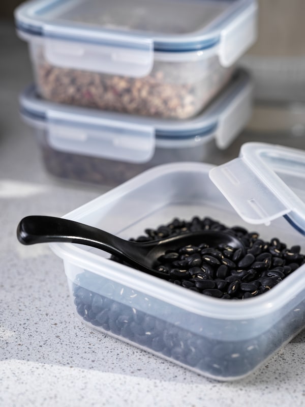 勺子在宜家365 +塑料食品容器用干黑豆亚博平台信誉怎么样,它的盖子。两个堆积附近。