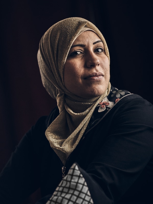 中东的女人穿着一件黑色上衣绣衣领,和浅褐色头巾,一个黑色的背景。