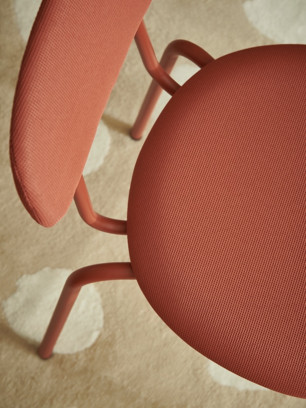 耀光冯oben auf死Sitzflache进行rotbraunen OSTANO Stuhls, der auf einem gepunkteten BOGENSE Teppich steht。
