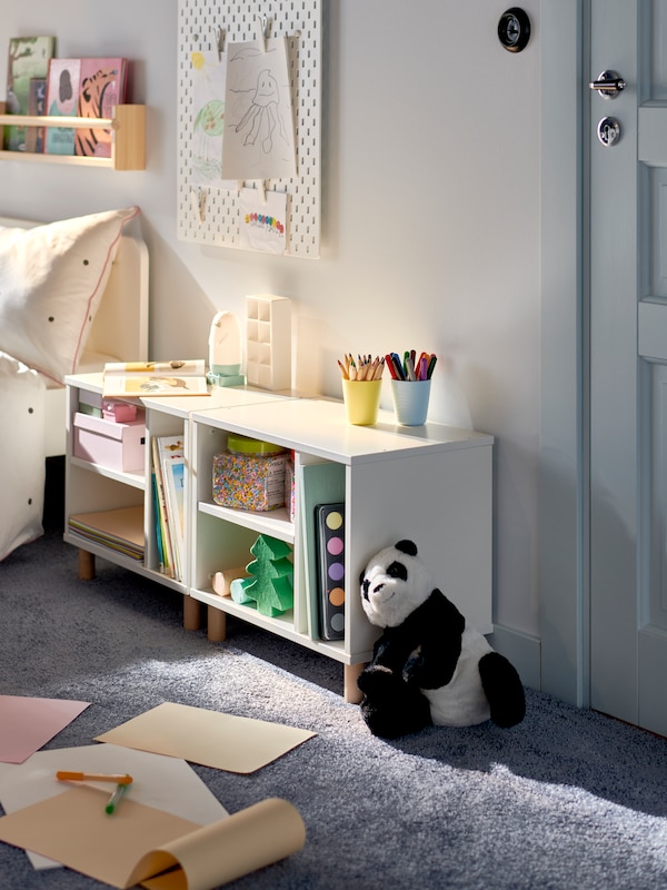 一个玩具熊猫靠着两个白色SMUSSLA床头柜上/货架单位站在彼此附近孩子的床上。