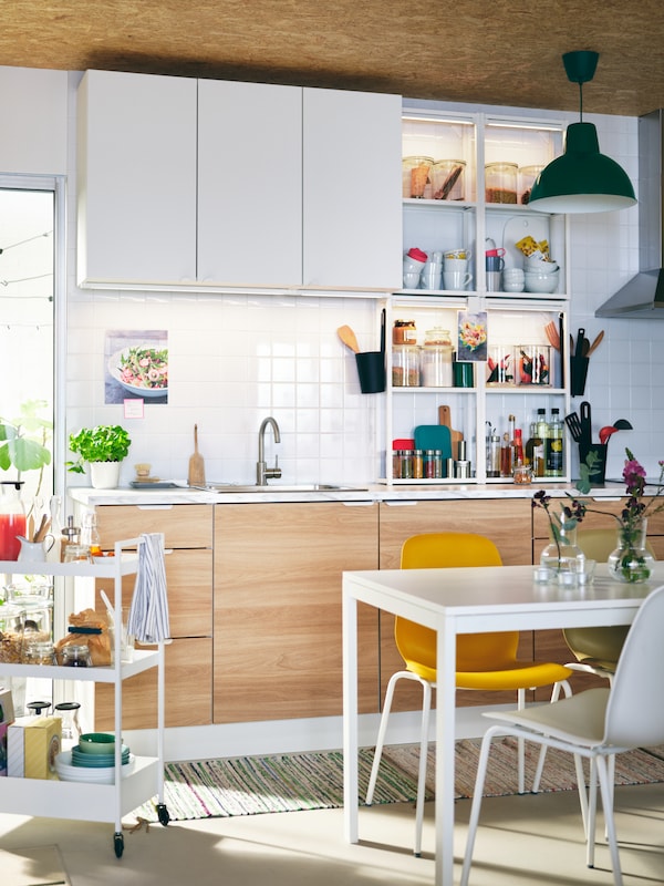 光与ENHET厨房橱柜、白色MELLTORP表,不同的颜色LEIFARNE椅子,和白色NISSAFORS电车。