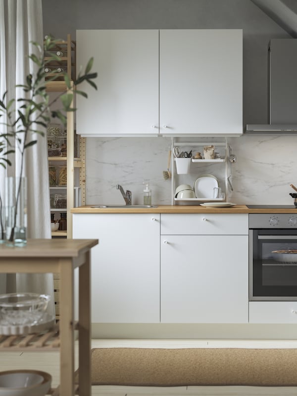 KNOXHULT厨房在白色MATALSKARE强迫空气炉和MATALSKARE壁装式排气罩在不锈钢。