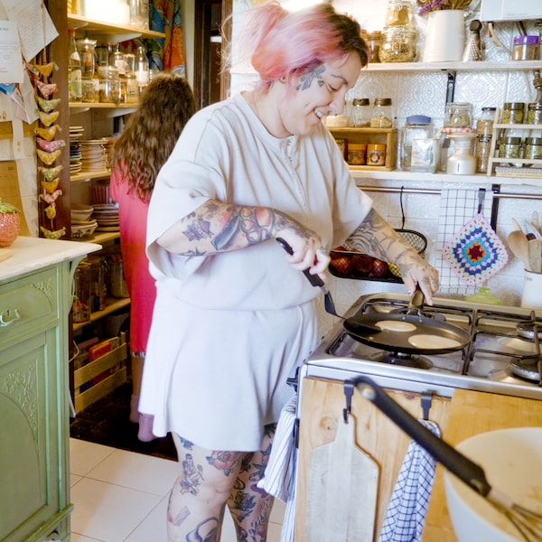 En smilende kvinde紫菜pandekager pa En HEMLAGAD pandekagepande pa komfuret。