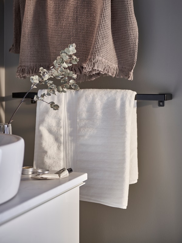 在黑白色的浴巾SKOGSVIKEN毛巾铁路、浅灰色/褐色浴巾挂在上面,加上一个白色摆好。