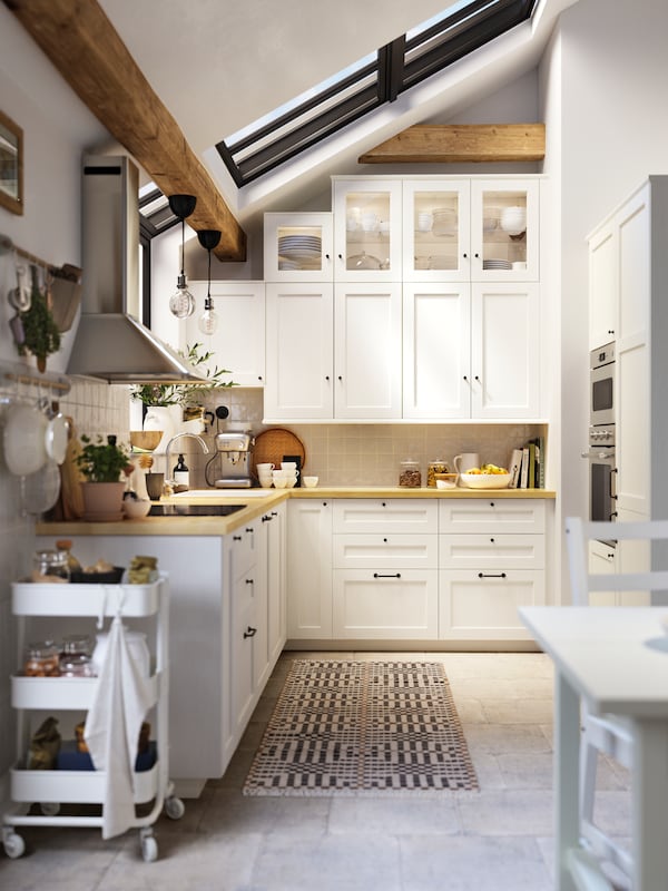 厨房ENKOPING白色wood-effect厨房领域,MATMASSIG感应滚刀和安装在墙上的排气罩。