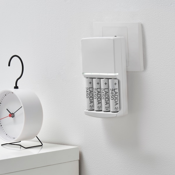 白墙与LADDA recharcheable电池充电KVARTS电池充电器一个时钟在白色的表。