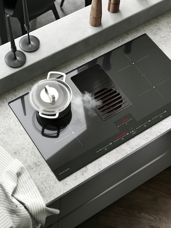 一个现代厨房FORNEBO感应滚刀提取蒸汽来自不锈钢HEMKOMST壶的盖子。