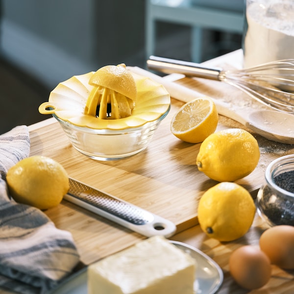 用半个柠檬UPPFYLLD柠檬榨汁器和UPPFYLLD手持刨丝器,在一个APTITLIG与柠檬切菜板。