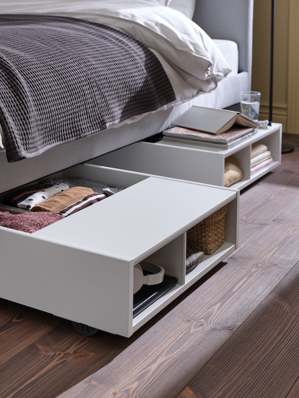 两FREDVANG床与床头柜拿着各种对象存储盒从下面一个浅灰色的床。
