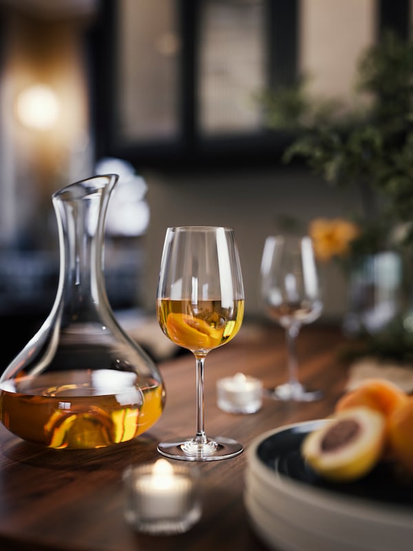 一个表与STORSINT在透明玻璃酒杯,一个STORSINT玻璃水瓶在透明玻璃,茶叶轻,一碗水果。