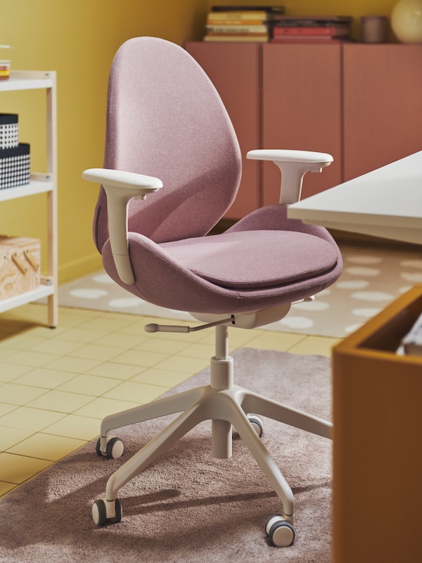 光brown-pink HATTEFJALL办公椅的扶手站旁边桌子坐/站在五颜六色的工作区。