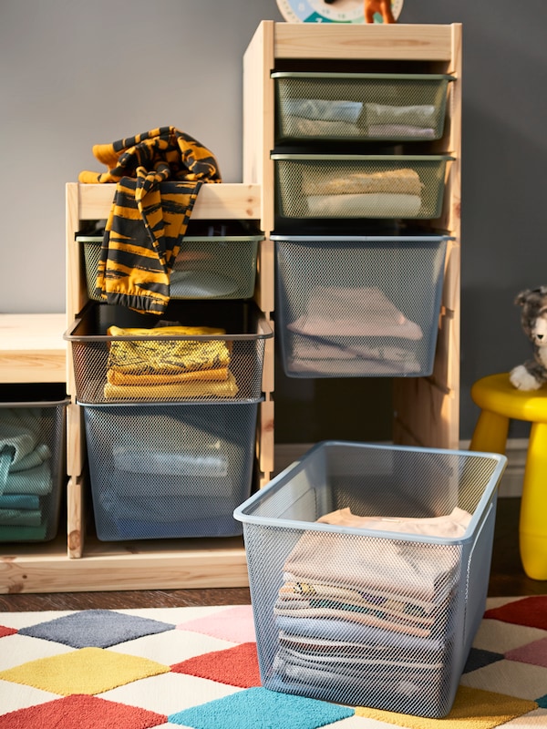 TROFAST存储结合松框架和网框在不同的颜色,和一个盒子拿出地毯。