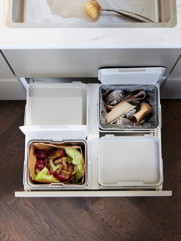 退出厨房抽屉里有四个HALLBAR垃圾箱在浅灰色。两个打开的食物浪费,纸张和纸板。