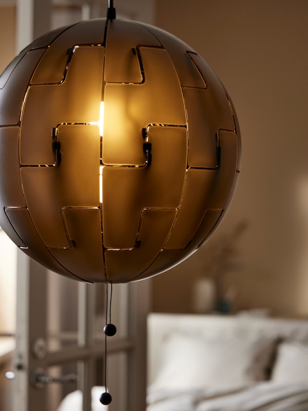 一个封闭的宜家PS亚博平台信誉怎么样 2014吊灯点亮挂在门附近的一个房间,米色墙与玻璃面板。