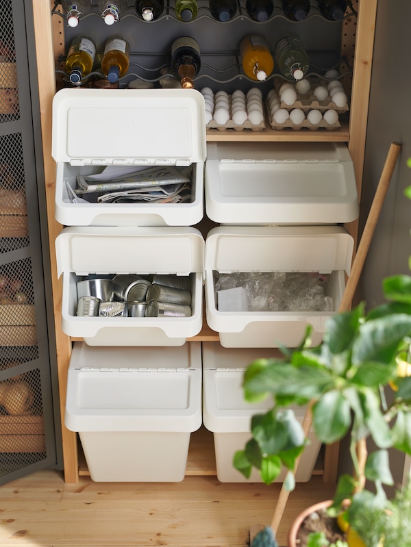 六白SORTERA废物分类垃圾箱盖子,在三两个堆栈,木架子单位下鸡蛋和瓶子。