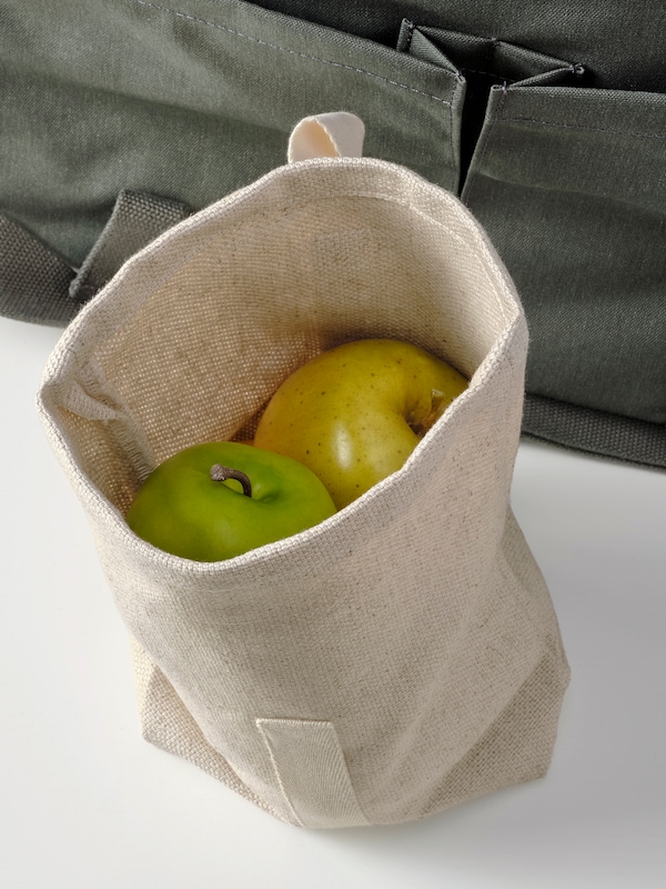 开放HAJMAL零食袋在天然纤维包含两个新鲜青苹果的一袋白色的表面。