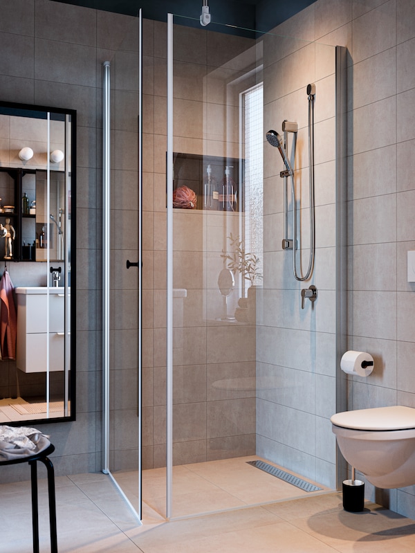 BROGRUND淋浴一起OPPEJEN淋浴屏和门安装在现代浴室铺着大米色砖。