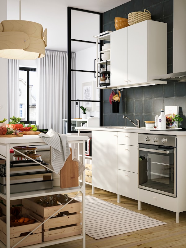 ENHET厨房的白色的开启和关闭存储和一个厨房岛与盒子和其他厨房用品。